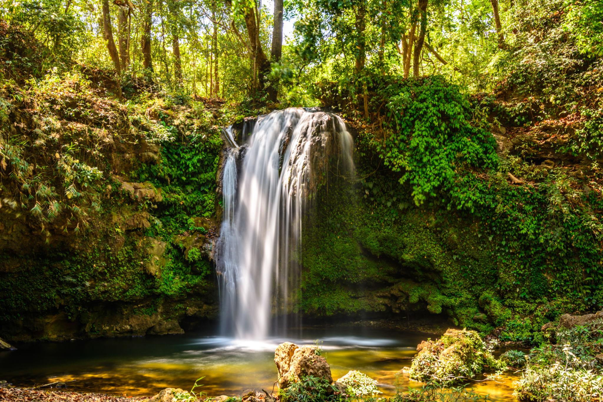 Beautiful waterfall near Jim Corbett National Park surrounded by lush green forest peaceful nature spot